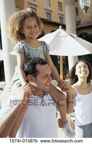 Stock Image - Daughter sitting on her father's shoulders. Fotosearch