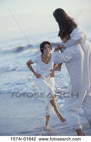 Father and mother together with their daughter at the beach View Large Photo Image Stock Image - Father and mother together with their daughter at the beach. Fotosearch