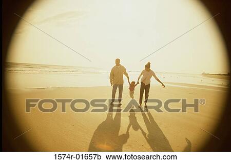 Stock Image - Father and mother with their daughter at the beach. Fotosearch