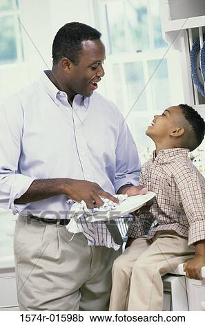 Stock Image - Father and son doing dishes together. Fotosearch