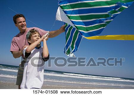 Father and son flying a kite at the beach View Large Photo Image Stock Photo - Father and son flying a kite at the beach. Fotosearch
