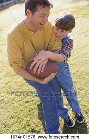 Stock Photograph - Father and son playing football. Fotosearch