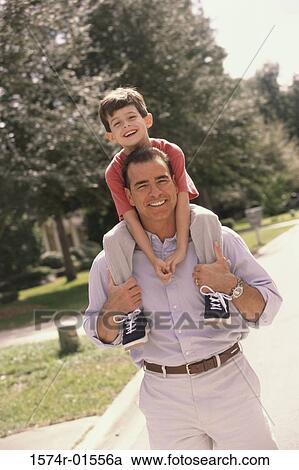 Father carrying his son on his shoulders View Large Photo Image Stock Image - Father carrying his son on his shoulders. Fotosearch