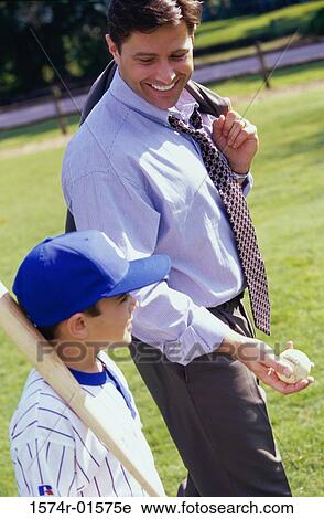 Father walking on a lawn with his son View Large Photo Image Stock Image - Father walking on a lawn with his son. Fotosearch