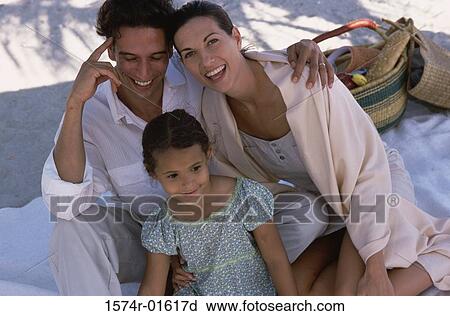 Stock Image - High angle view of a couple at a picnic with their daughter. Fotosearch