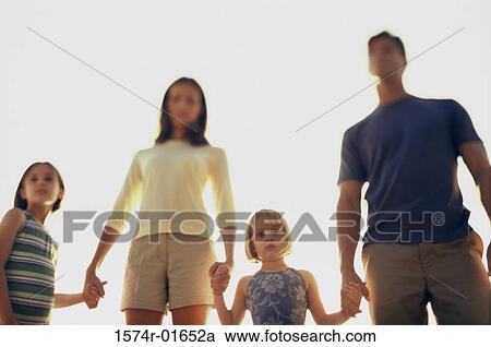 Stock Image - Low angle view of a mother and father with their two daughters. Fotosearch