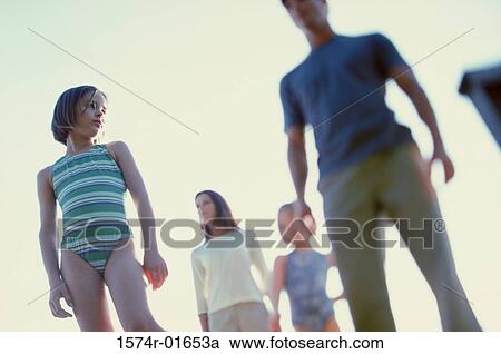 Stock Image - Low angle view of a mother and father standing with their two daughters. Fotosearch