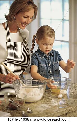 Stock Image - Mother and daughter baking together. Fotosearch