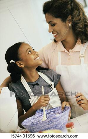Stock Photograph - Mother and daughter cooking together. Fotosearch