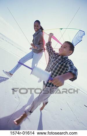 Picture - Mother and son flying a kite on the beach. Fotosearch