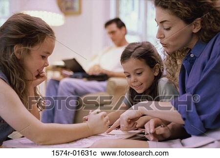 Stock Image - Mother studying with her two children. Fotosearch