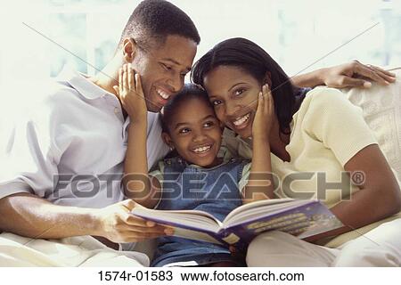 Parents and their daughter sitting together on a couch View Large Photo Image Stock Image - Parents and their daughter sitting together on a couch. Fotosearch
