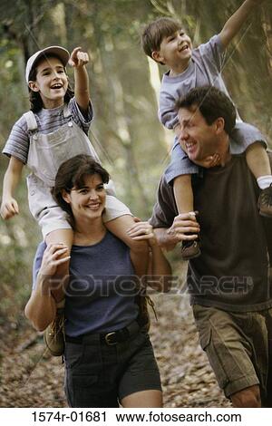 Stock Image - Parents and their two children in a forest. Fotosearch