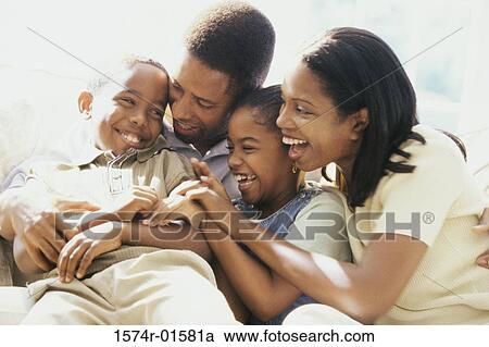 Stock Image - Parents and their two children playing. Fotosearch