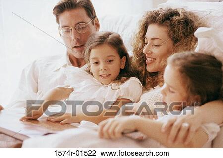 Parents and their two daughters together in bed View Large Photo Image Stock Image - Parents and their two daughters together in bed. Fotosearch