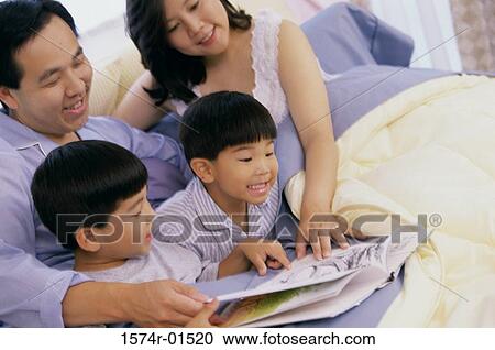 Parents reading a book to their two sons View Large Photo Image Stock Image - Parents reading a book to their two sons. Fotosearch