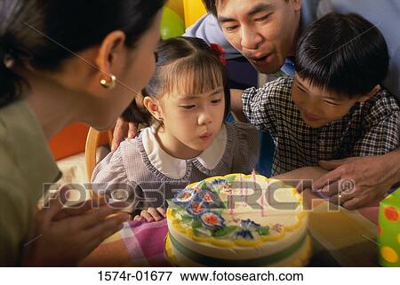 Parents with their children in front of a birthday cake View Large Photo Image Stock Photo - Parents with their children in front of a birthday cake. Fotosearch