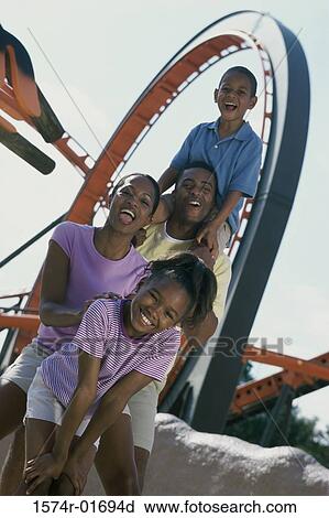 Portrait of a couple at an amusement park with their son and daughter View Large Photo Image Stock Image - Portrait of a couple at an amusement park with their son and daughter. Fotosearch