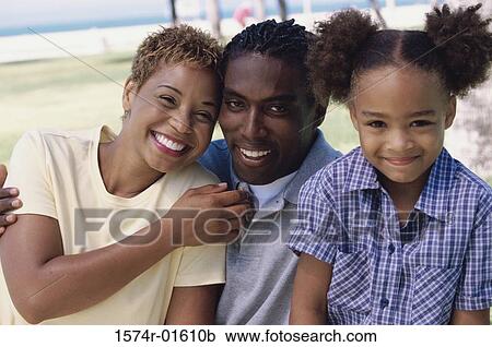 Stock Image - Portrait of a couple in the park with their daughter. Fotosearch