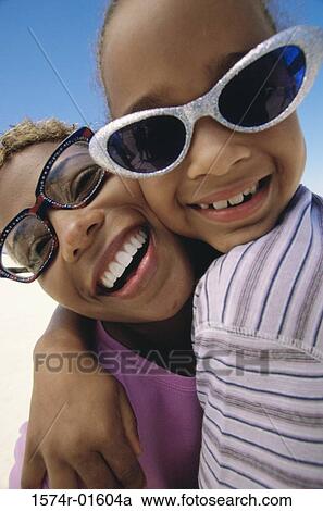 Stock Image - Portrait of a mother and daughter wearing sunglasses. Fotosearch