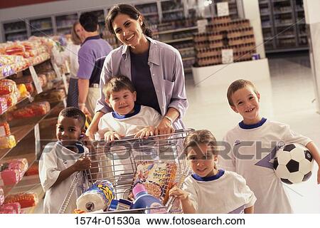 Portrait of a woman grocery shopping with four children from a football team View Large Photo Image Stock Image - Portrait of a woman grocery shopping with four children from a football team. Fotosearch