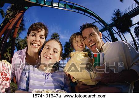 Stock Image - Portrait of parents and their two children in an amusement park. Fotosearch