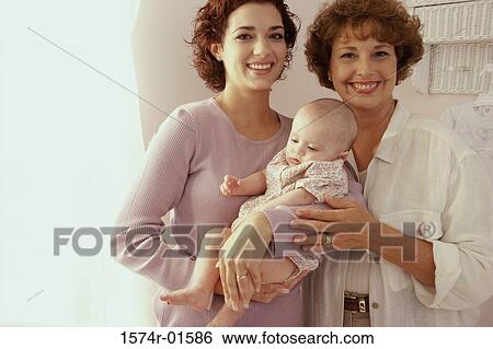 Stock Photograph - Portrait of two women holding a baby. Fotosearch