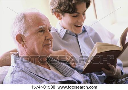 Teenage boy reading to an elderly man View Large Photo Image Stock Photo - Teenage boy reading to an elderly man. Fotosearch