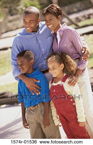 Young couple standing outdoors with their son and daughter View Large Photo Image Stock Photograph - Young couple standing outdoors with their son and daughter. Fotosearch