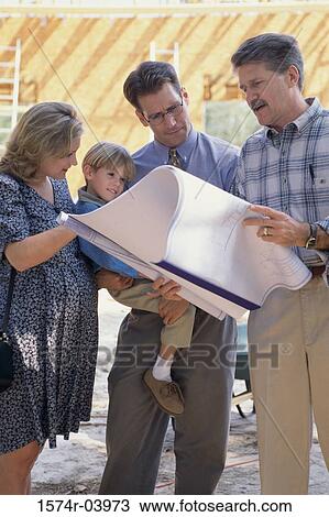 Stock Image - Architect discussing blueprints with a family. Fotosearch