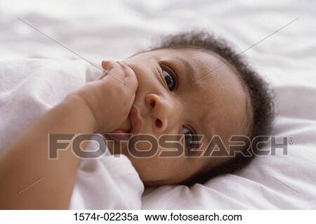 Stock Image - Close-up of a baby boy sucking his thumb. Fotosearch