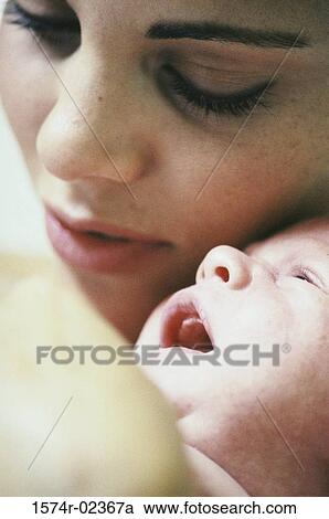 Stock Image - Close-up of a mother carrying her baby boy. Fotosearch