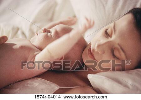 Close-up of a mother lying down with her baby boy View Large Photo Image Picture - Close-up of a mother lying down with her baby boy. Fotosearch