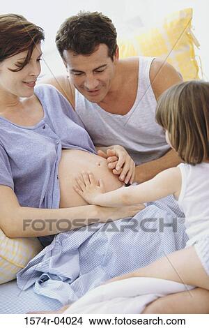 Daughter touching his pregnant mother's abdomen View Large Photo Image Picture - Daughter touching his pregnant mother's abdomen. Fotosearch