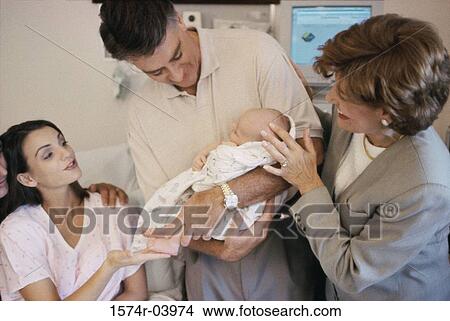 Picture - Grandparents carrying their baby boy in the hospital. Fotosearch