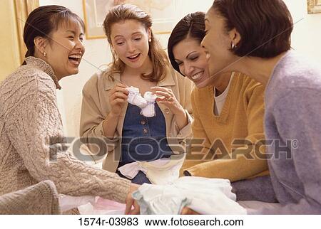 Stock Image - Group of young women with presents at a baby shower. Fotosearch