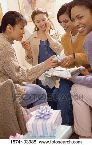 Stock Photography - Group of young women with presents at a baby shower. Fotosearch