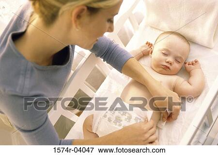 High angle view of a mother changing diaper of sleeping baby boy View Large Photo Image Stock Photo - High angle view of a mother changing diaper of sleeping baby boy. Fotosearch