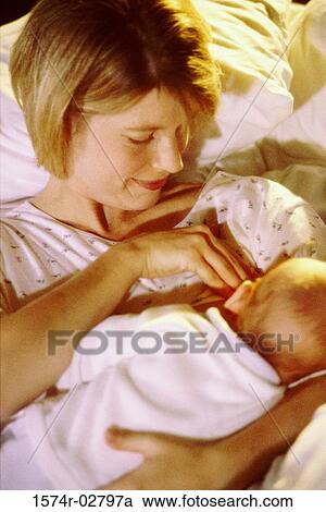Stock Image - High angle view of a mother breastfeeding her baby boy. Fotosearch