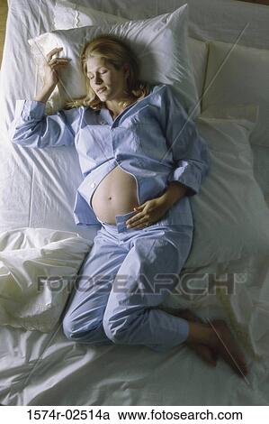 High angle view of a pregnant woman sleeping on a bed View Large Photo Image Stock Image - High angle view of a pregnant woman sleeping on a bed. Fotosearch
