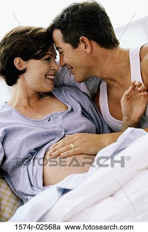 Husband lying in bed with his pregnant wife View Large Photo Image Stock Image - Husband lying in bed with his pregnant wife. Fotosearch