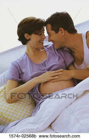 Husband lying in bed with his pregnant wife View Large Photo Image Stock Image - Husband lying in bed with his pregnant wife. Fotosearch