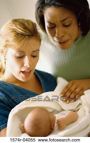 Mother holding her baby boy with a friend standing beside in hospital View Large Photo Image Stock Photography - Mother holding her baby boy with a friend standing beside in hospital. Fotosearch