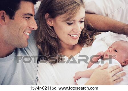 Stock Image - Parents carrying their baby boy. Fotosearch