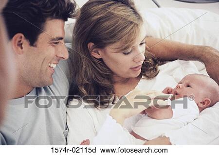 Stock Image - Parents carrying their baby boy. Fotosearch