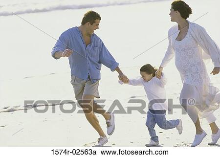 Parents running on the beach with their daughter View Large Photo Image Stock Image - Parents running on the beach with their daughter. Fotosearch