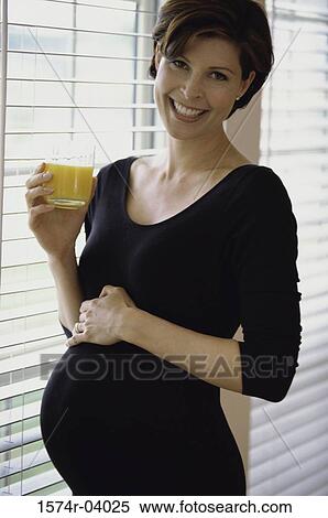 Portrait of a pregnant young woman holding a glass of juice View Large Photo Image Stock Photography - Portrait of a pregnant young woman holding a glass of juice. Fotosearch