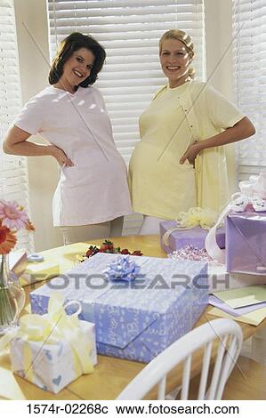 Stock Image - Portrait of two pregnant women standing at a baby shower. Fotosearch