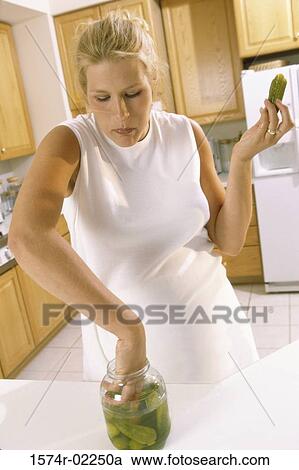 Pregnant woman taking pickles from a jar View Large Photo Image Stock Image - Pregnant woman taking pickles from a jar. Fotosearch