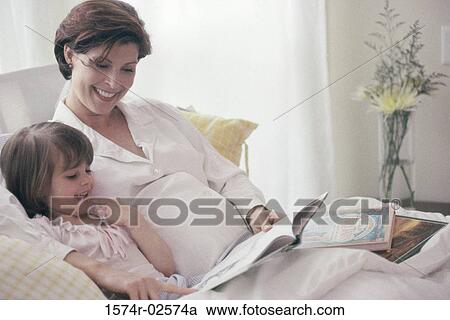 Stock Image - Pregnant woman teaching her daughter. Fotosearch